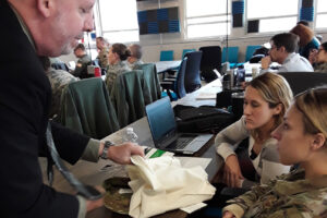 2 women and demonstrator looking at material