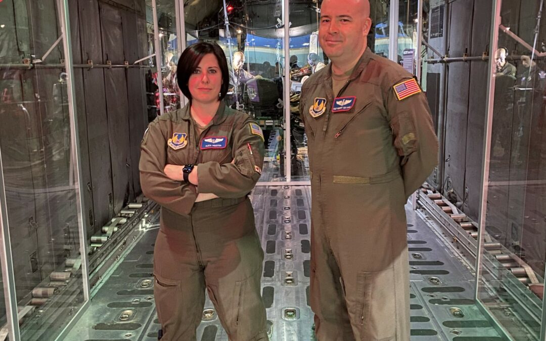 Tech Sgt. Robert Van Aken and Capt. Alicia Houston standing in front of the Transport Isolation System (TIS)