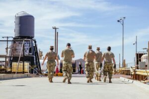 Airmen handling large pipe feeding cryogenic rocket propellants for liquid rocket CONOPS and novel deployable systems tests.