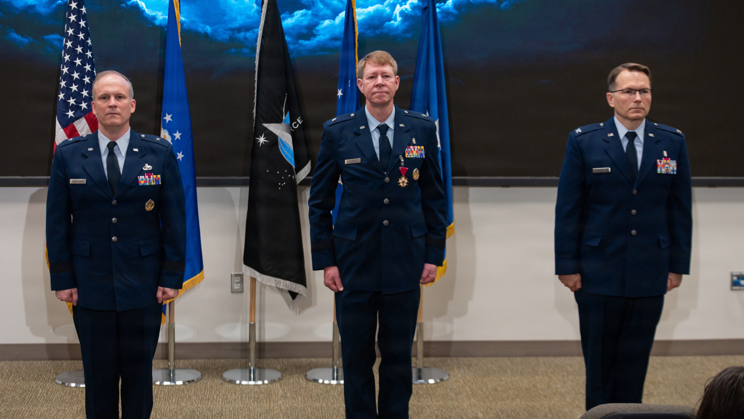 leaders stand during change of command ceremony