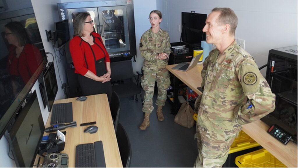 Brig. Gen. Wickert, commander, Air Force Research Lab, takes place in a brief headed by another airmen and civilian.