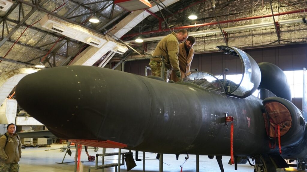 AFRL civilian and airmen look into the cockpit of a U-2 stealth aircraft at the 5th Reconnaissance Squadron (RS), Osan AFB, Republic of Korea.