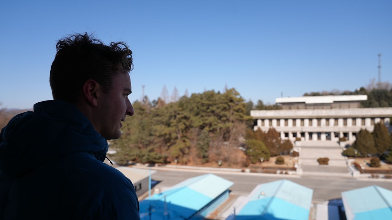 An airmen stands in the forefront, looking out towards the Join Security Area inside the Demilitarized Zone in Panmunjom, Republic of Korea.