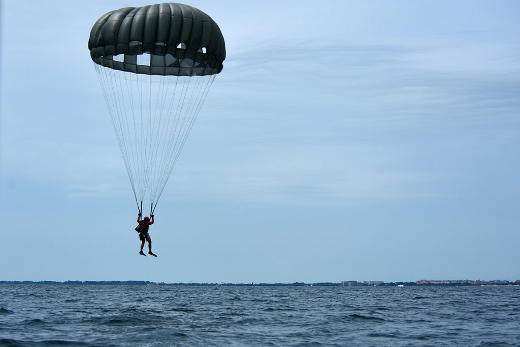 image of a parachuter over water