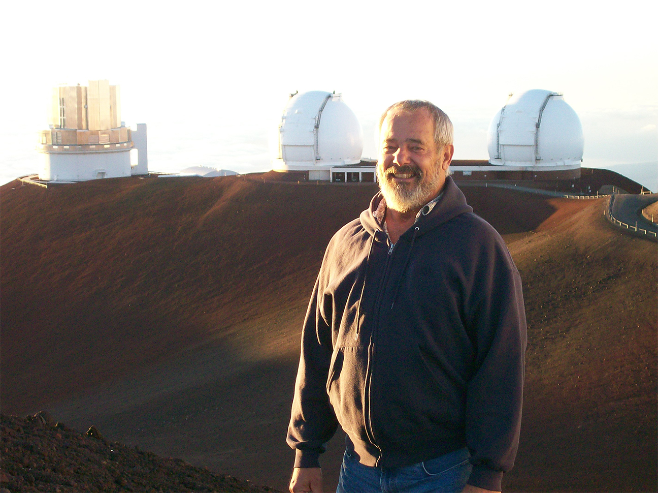image of researcher in front of large telescope facilities