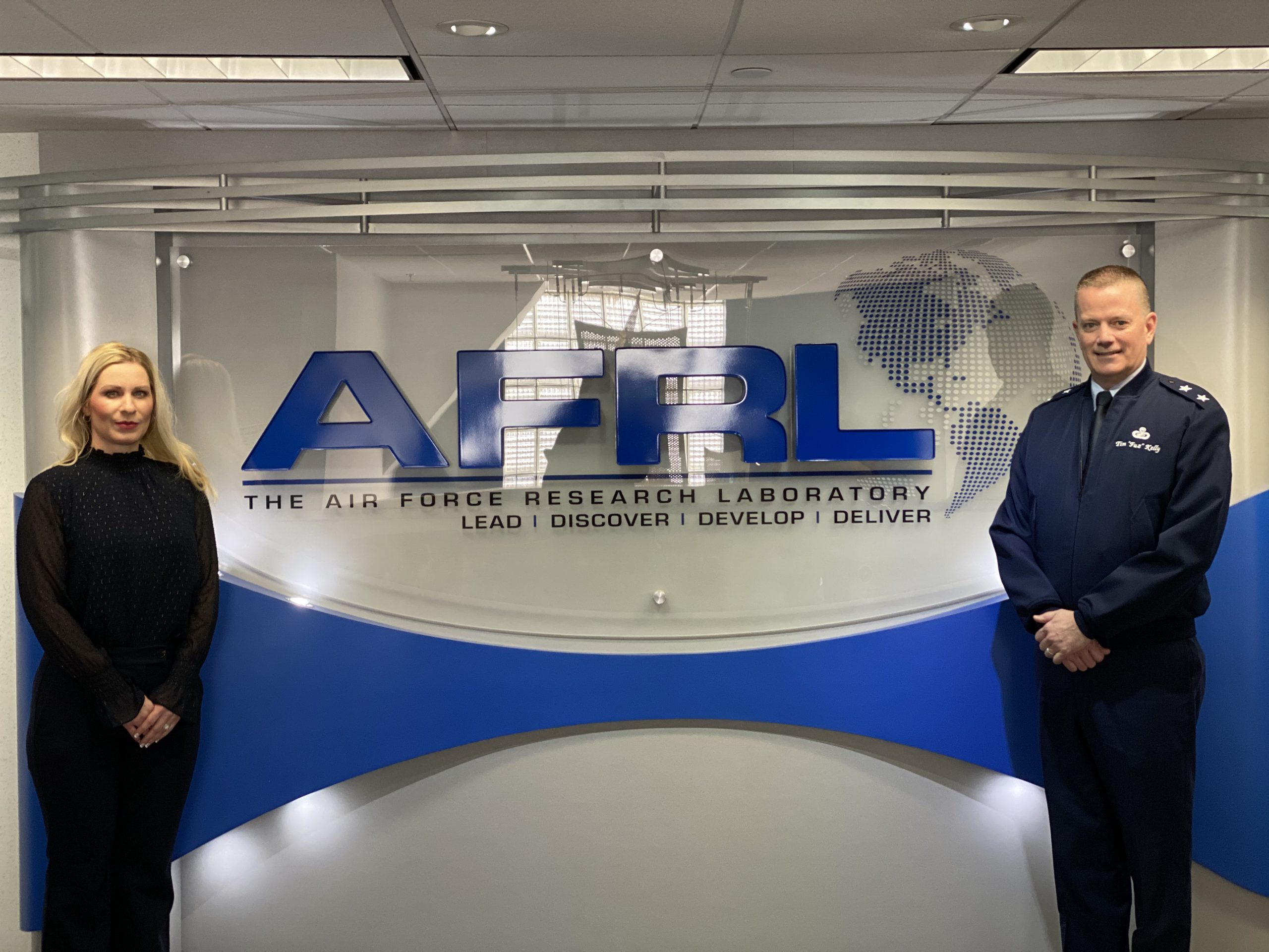 Two podcast speakers in front of AFRL signage