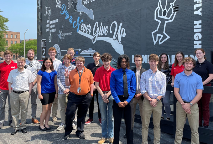 17 interns stand in front of building