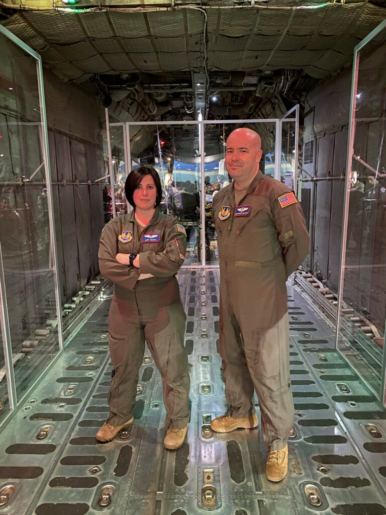 Tech Sgt. Robert Van Aken and Capt. Alicia Houston standing in front of the Transport Isolation System (TIS)