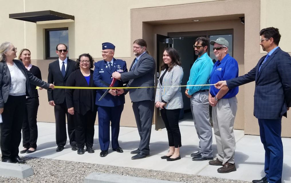 Col. Eric Felt is flanked by a number of researchers and officials while cutting the ribbon officially opening the AFRL Skywave Technology Lab