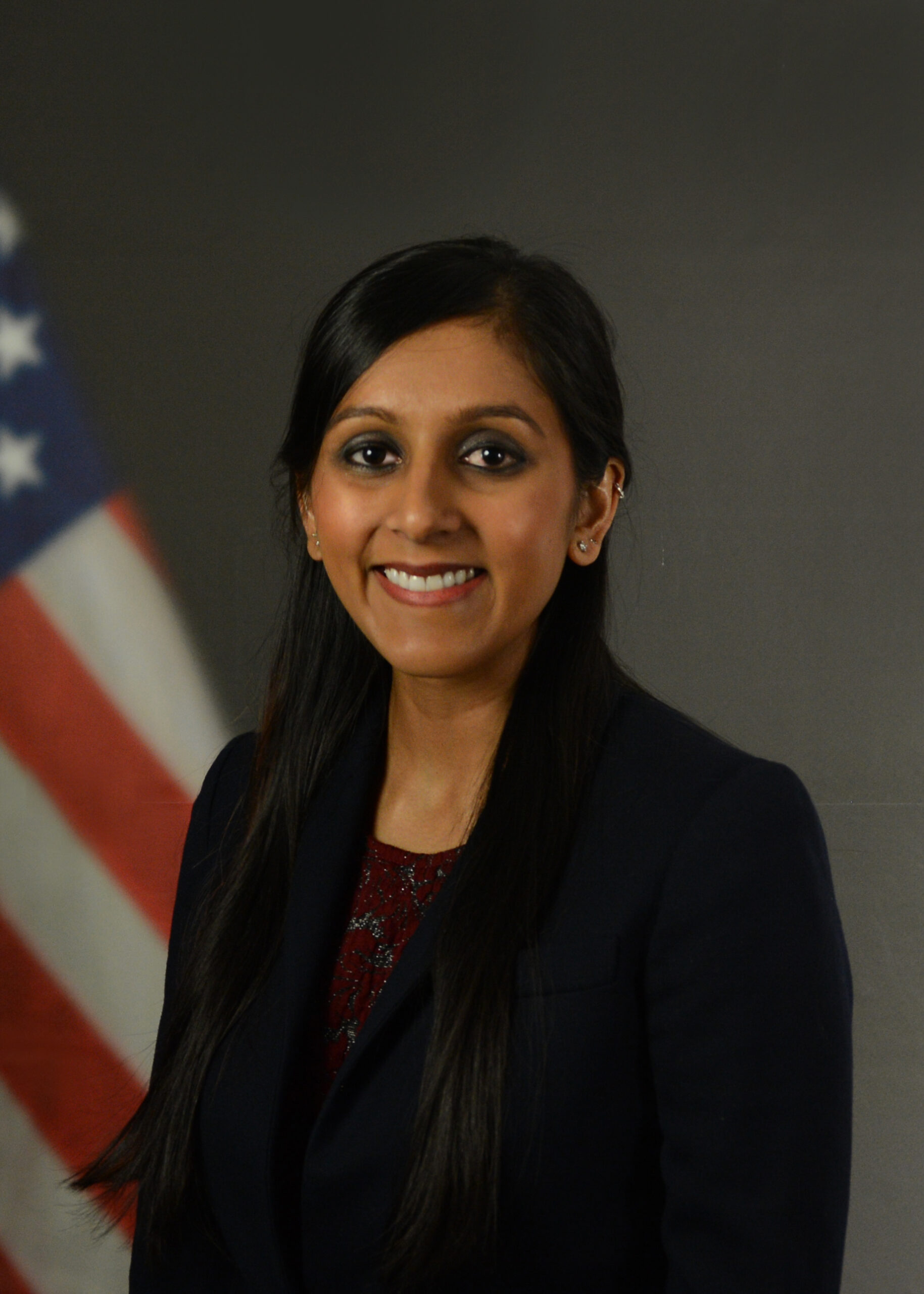 Dr. Tulsi Patel smiling and wearing a suit.