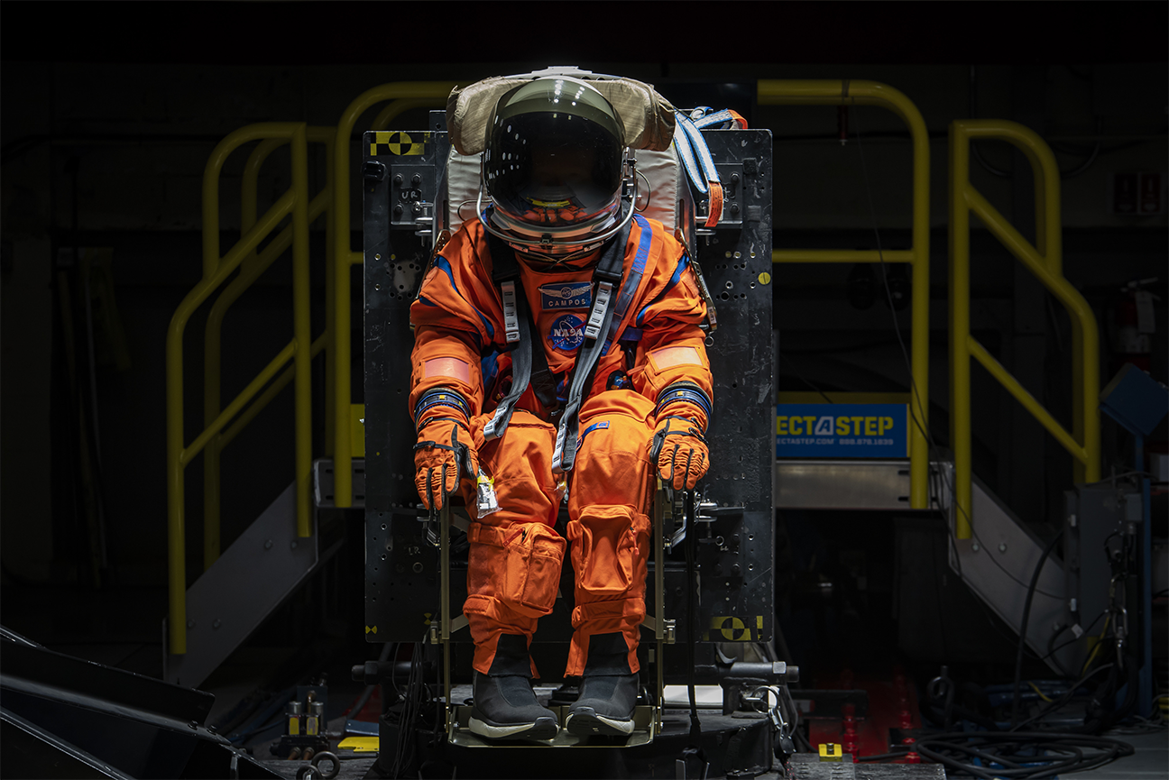 NASA staff testing seat and flight suit for safety measures