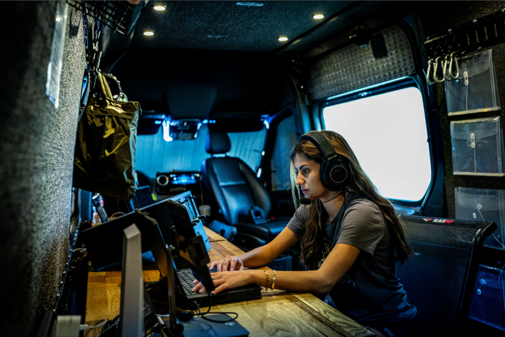 Engineer monitors test on laptop within a vehicle.