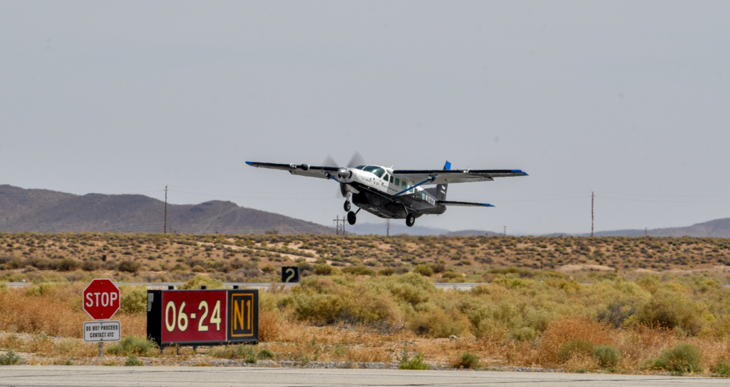 Cessna craft flying low over dry scrublands.