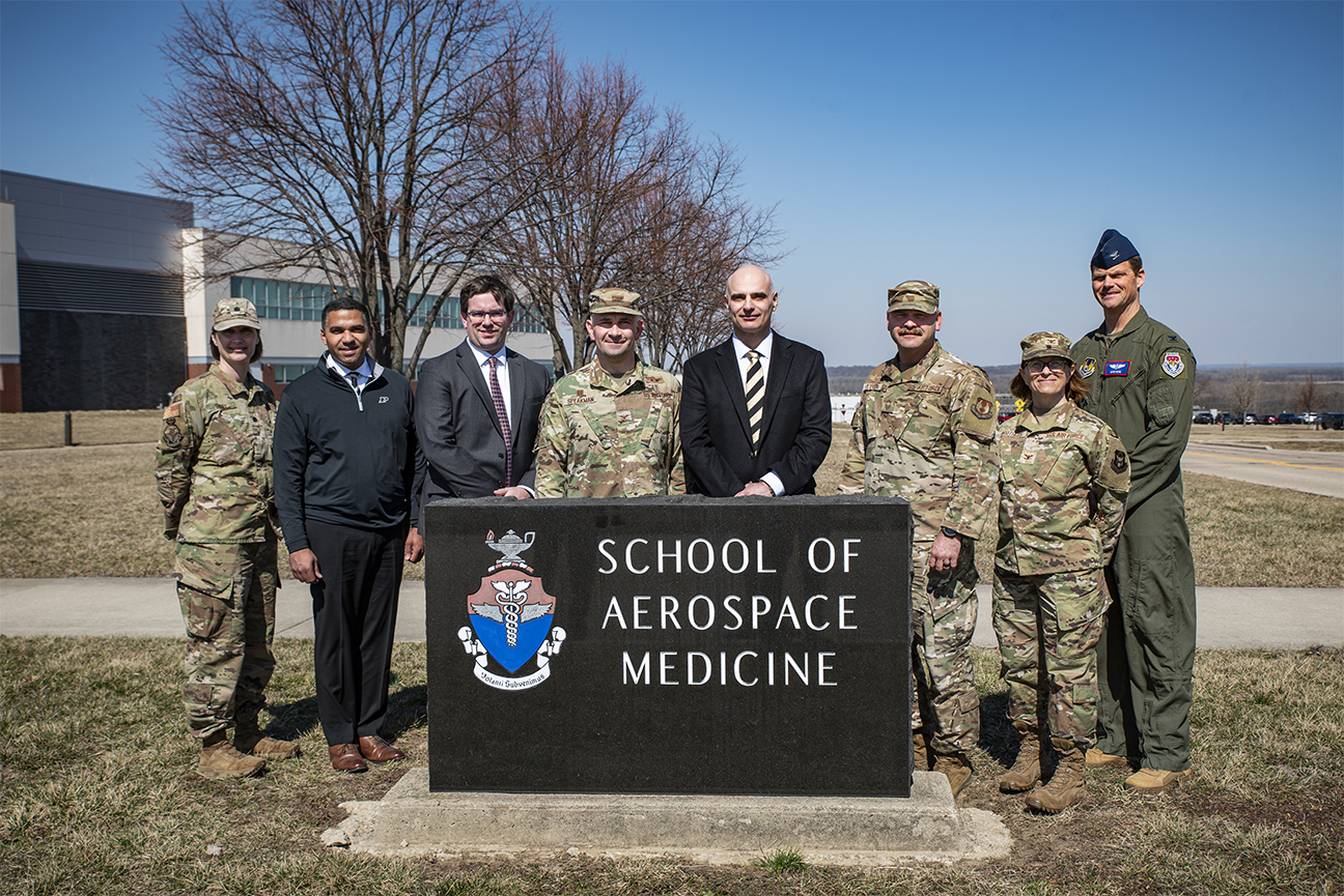 leaders from USAFSAM and Purdue posing around a USAFSAM outdoor sign
